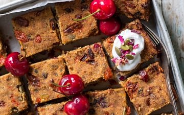 Nut Free Vegan Fruit Slice in baking tray topped with coconut yoghurt and fresh cherries!
