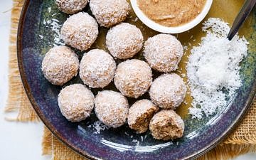 Protein balls rolled in desiccated coconut on a blue ceramic plate