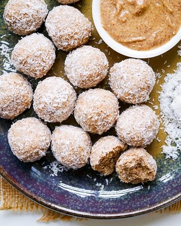 Protein balls rolled in desiccated coconut on a blue ceramic plate