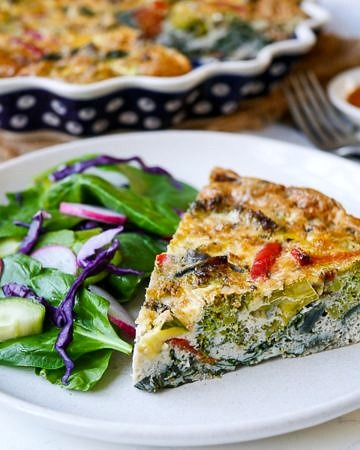 This pesto vegetable frittata makes an easy, healthy meal that can be made ahead of time. Gluten free and grain free, a simple delicious way to get in your veggies! Recipe by Nourish Everyday