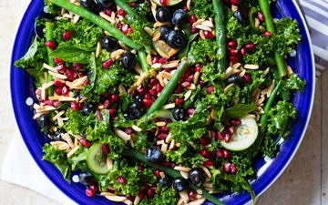 Summery blueberry kale salad featuring massaged kale, green beans, cucumber, mint, blueberries, pomegranate and toasted almonds. Yum!