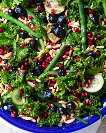 Summery blueberry kale salad featuring massaged kale, green beans, cucumber, mint, blueberries, pomegranate and toasted almonds. Yum!
