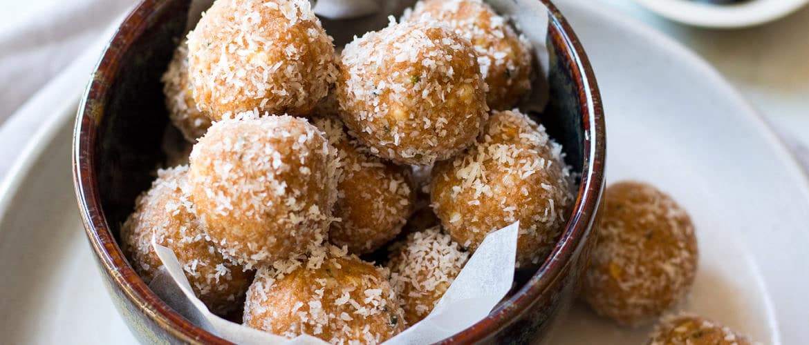 No food processor Paleo Protein Balls, all stacked in a bowl! Combining crunchy nut butter, coconut, hemp seeds, a little honey and your favourite protein powder.