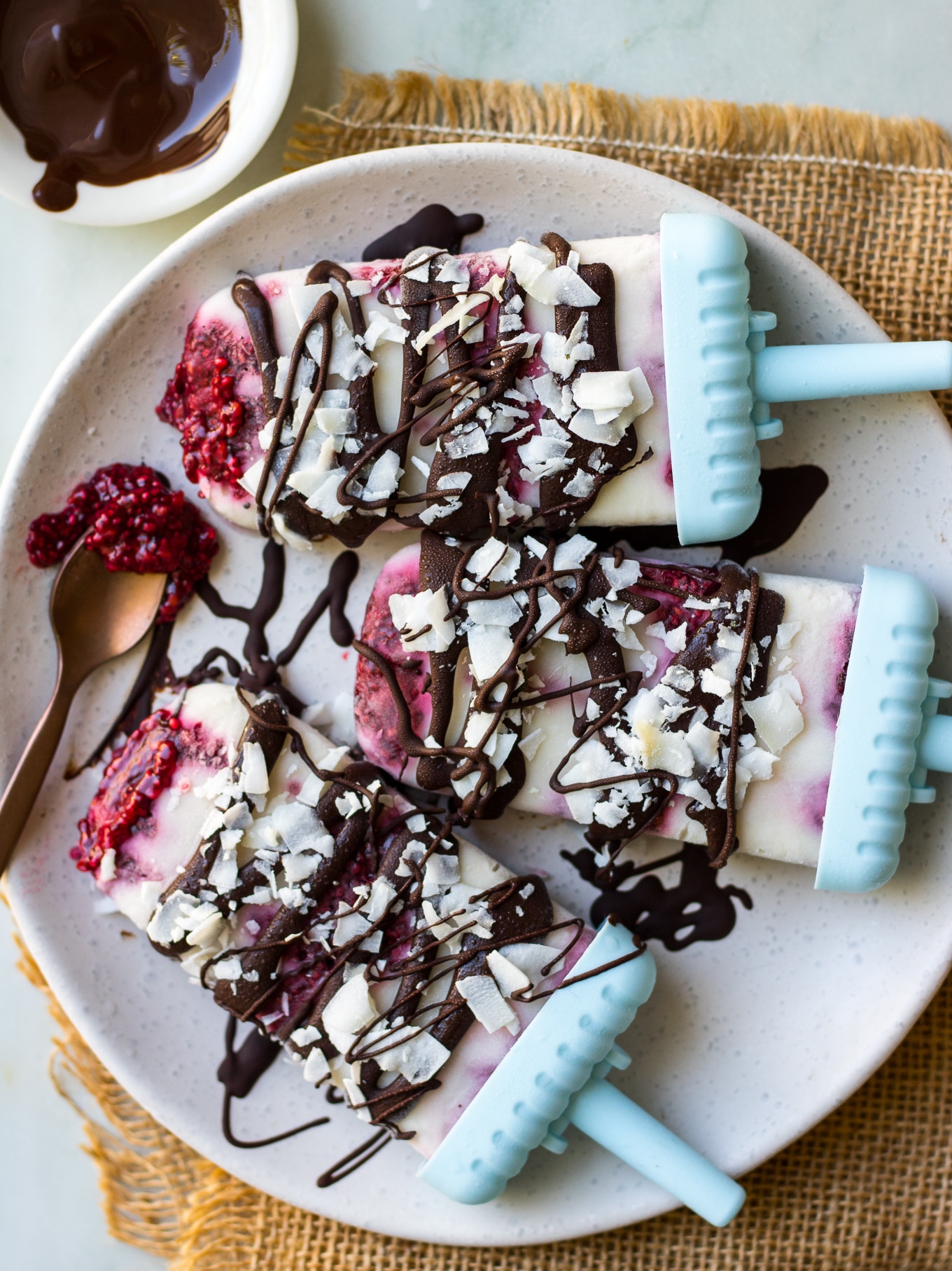 Creamy coconut lamington popsicles with raspberry chia jam, dark chocolate and coconut flakes. These dairy free, #vegan frozen treats are a fun healthy way to get a lamington fix! #popsicles #lamington #dairyfree