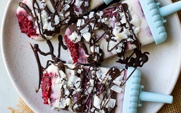 Vegan creamy coconut lamington popsicles drizzled in dark chocolate and sprinkled with coconut flakes.