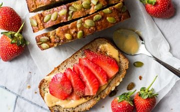 Slices of apple zucchini snack cake from top down, one flat topped with sliced strawberries