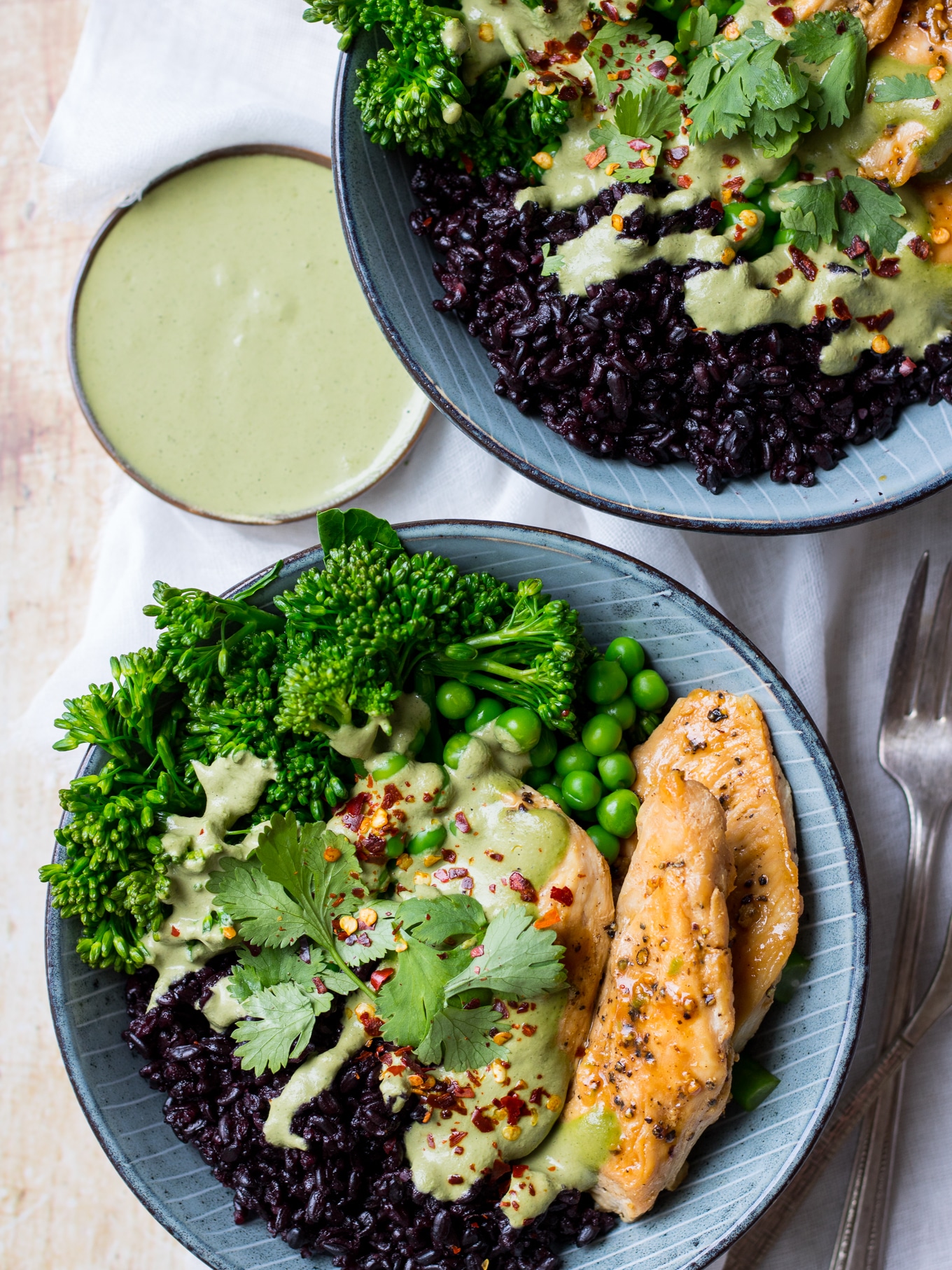 Blue bowls, chicken black rice bowls, layered with black rice, marinated chicken, peas, broccolini, green cashew herb sauce