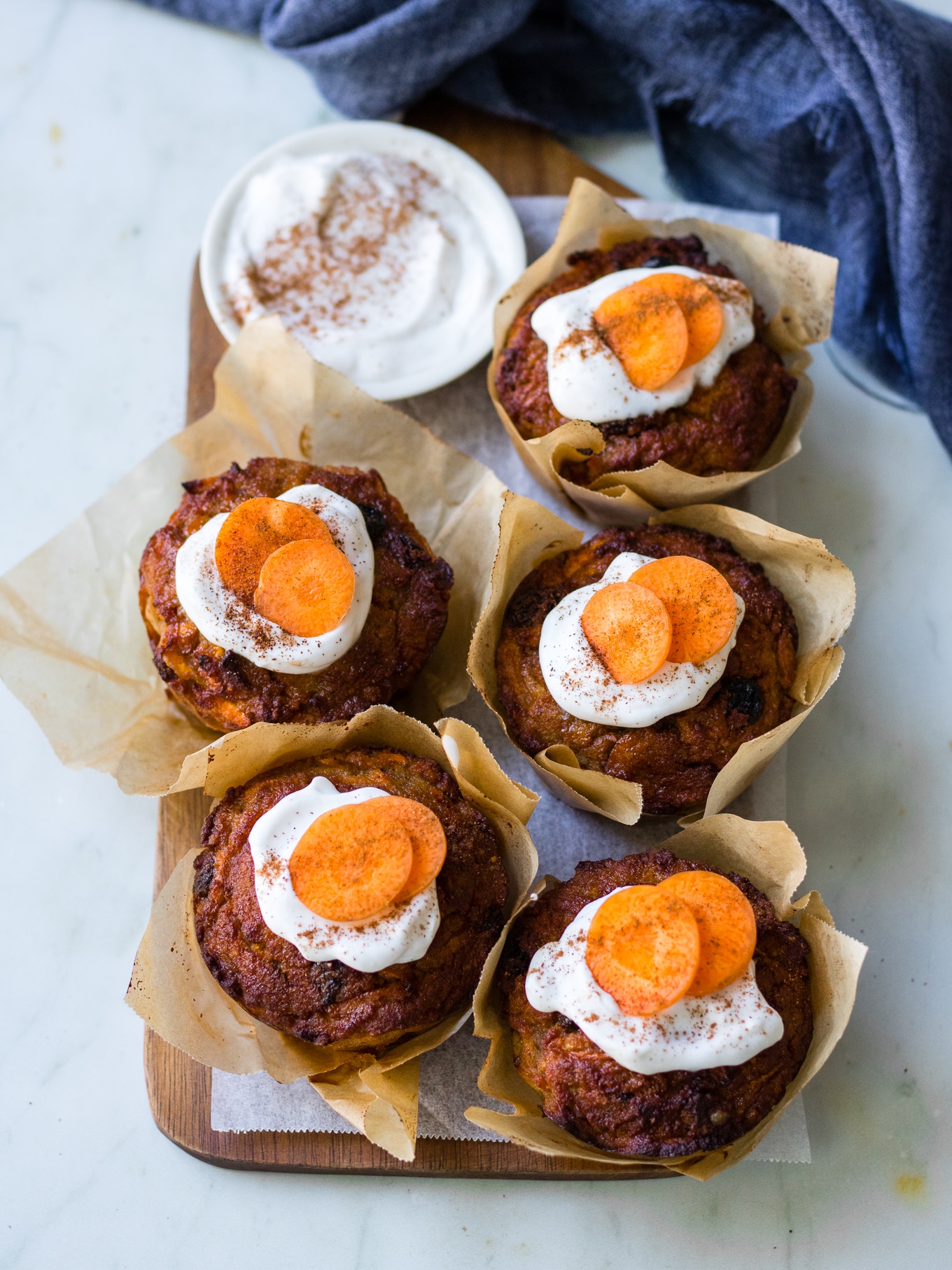 Healthy Carrot Cake Muffins, five muffins arranged in rows on wooden chopping board