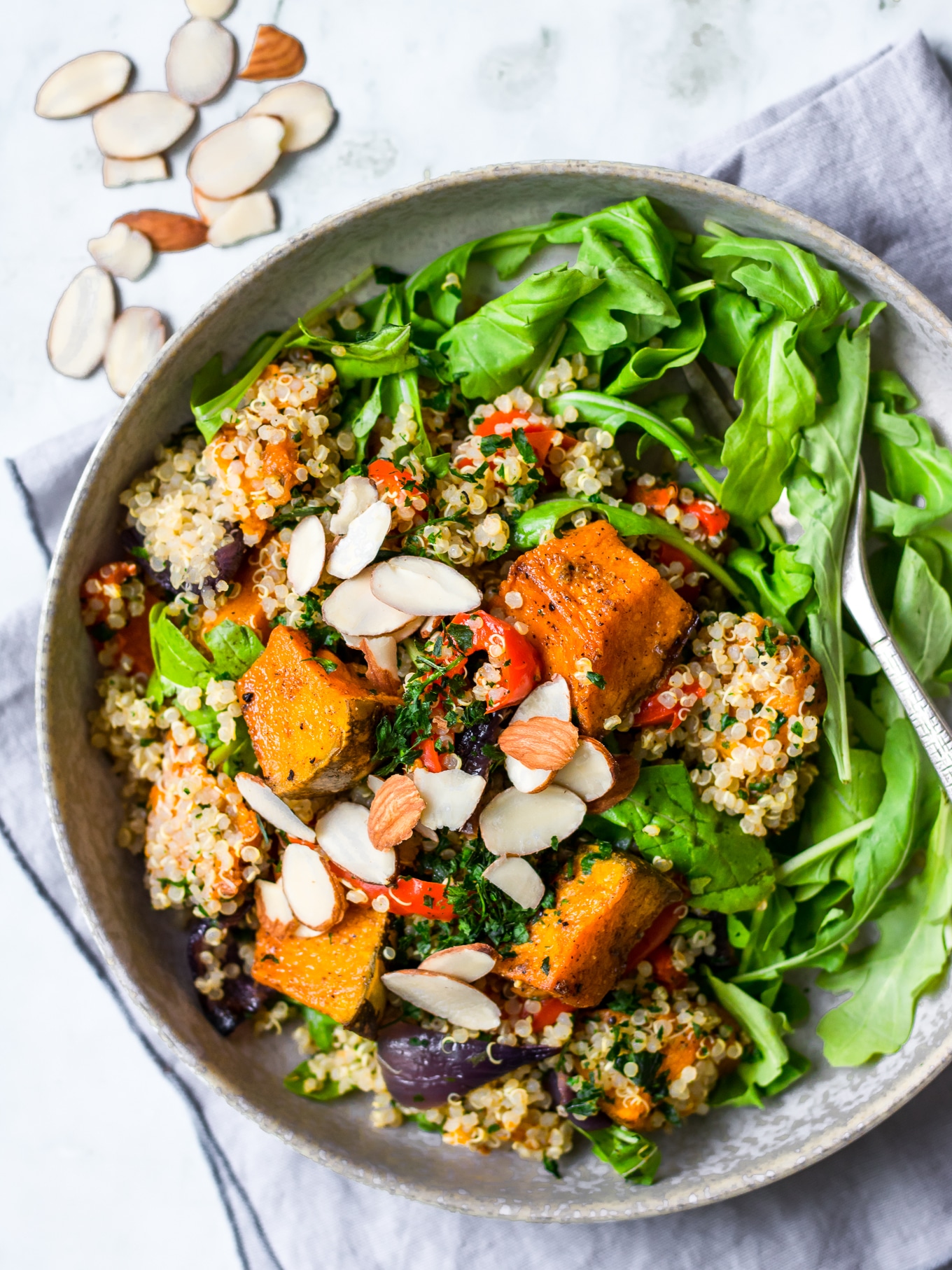 Honey roast pumpkin quinoa salad top down view, flaked almonds on top and round bowl