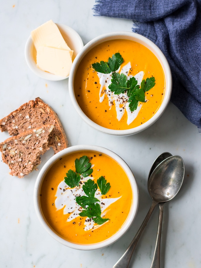 coconut ginger pumpkin soup bowl garnished with coconut cream and herbs