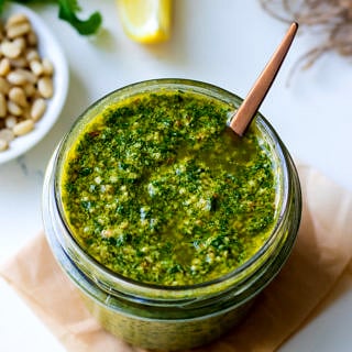 Lemon basil pesto in a small glass jar with spoon