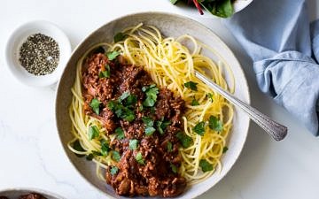 Red Wine Bolognese in ceramic bowl, spaghetti, parsley garnish