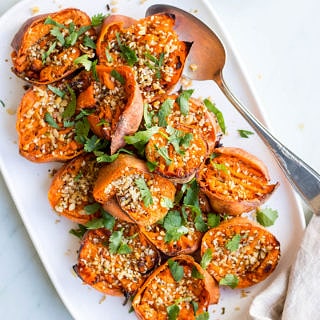 Smashed Sweet Potatoes with Dukkah on white serving dish