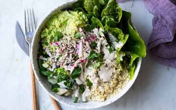vegan protein buddha bowls with green vegetables, avocado smash, quinoa in white speckled bowls