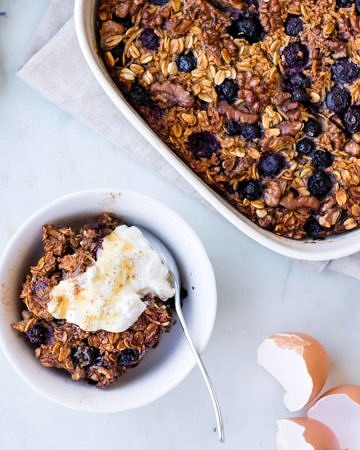 coconut blueberry baked oats with Greek yoghurt dish and serving bowl