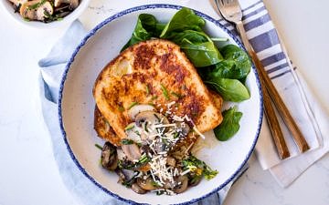 Savoury french toast with mushrooms and grated parmesan, white bowl