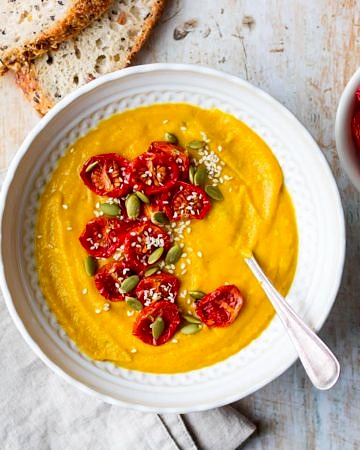 Cauliflower, sweet potato and red lentil soup in white patterned bowl with bread