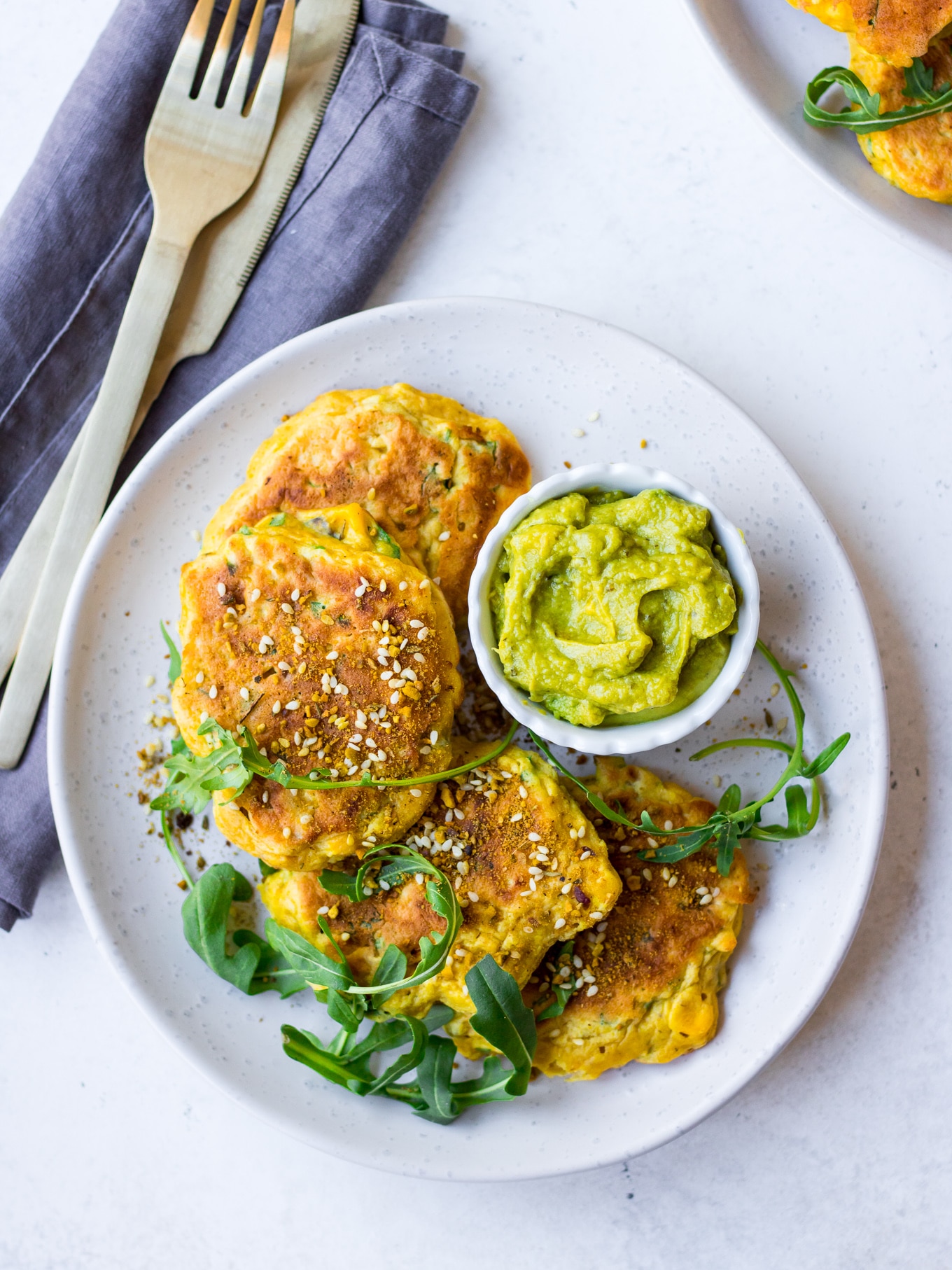 Gluten Free Corn Fritters arranged with rocket on grey ceramic plate | Nourish Every Day Blog