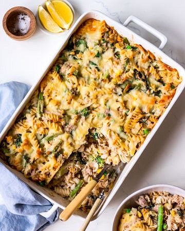 Creamy tuna pasta bake flat lay with bowl and condiments