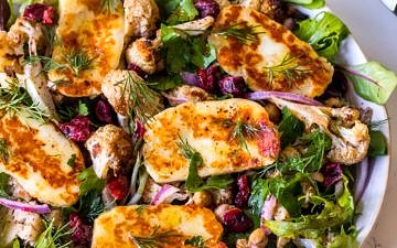Close view of roasted cauliflower salad topped with fried halloumi slices