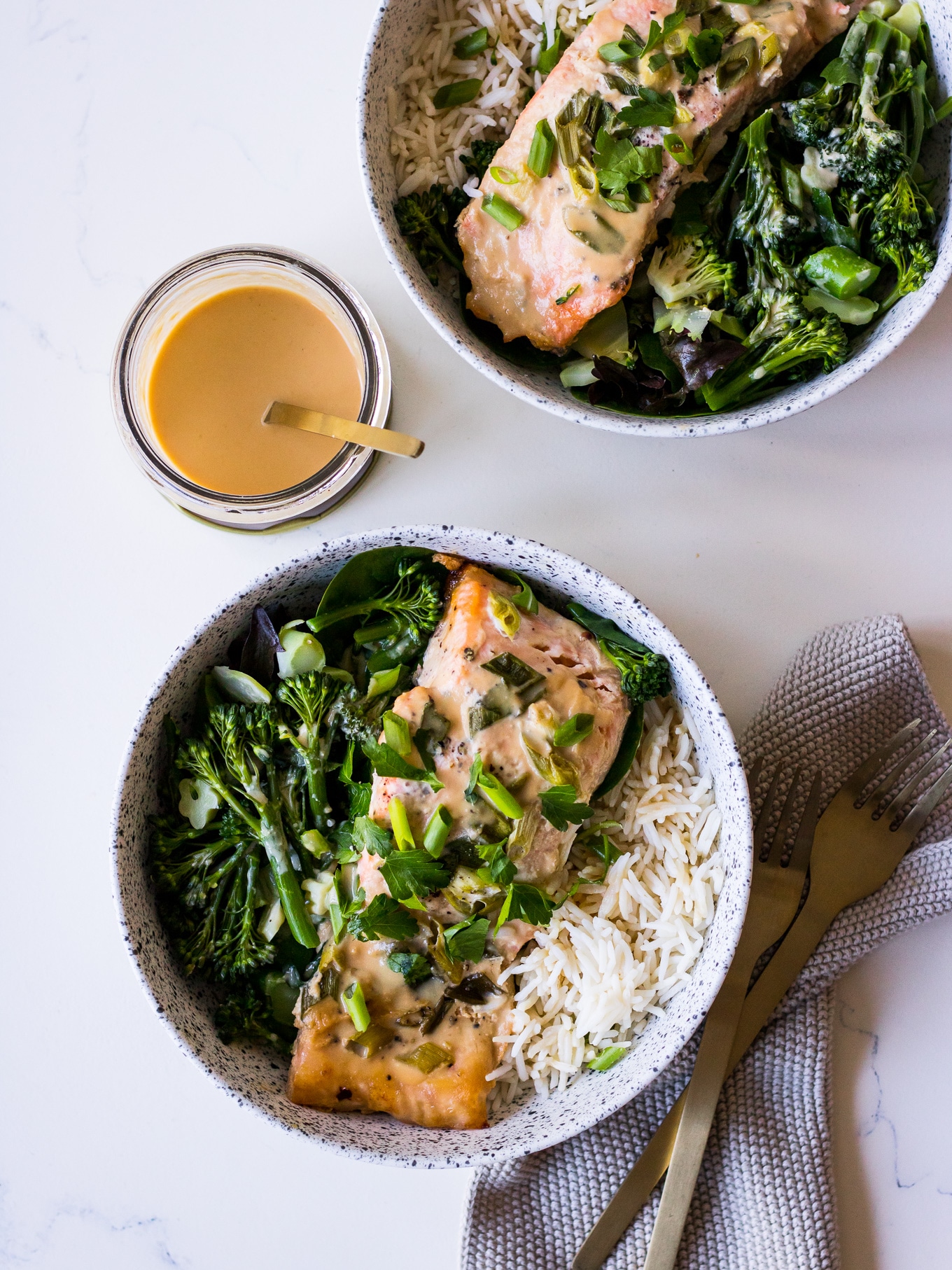 Tahini Miso Salmon in speckled white bowls with miso sauce jar