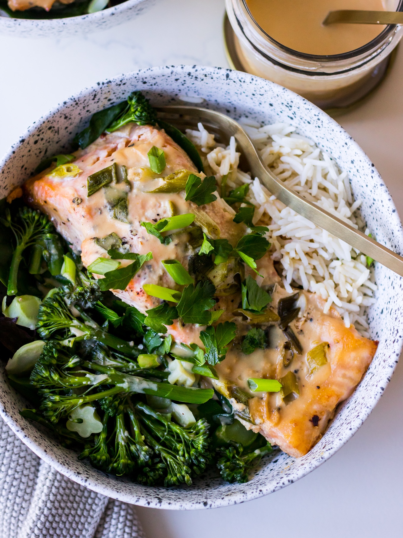 Close up tahini miso baked salmon with greens and rice
