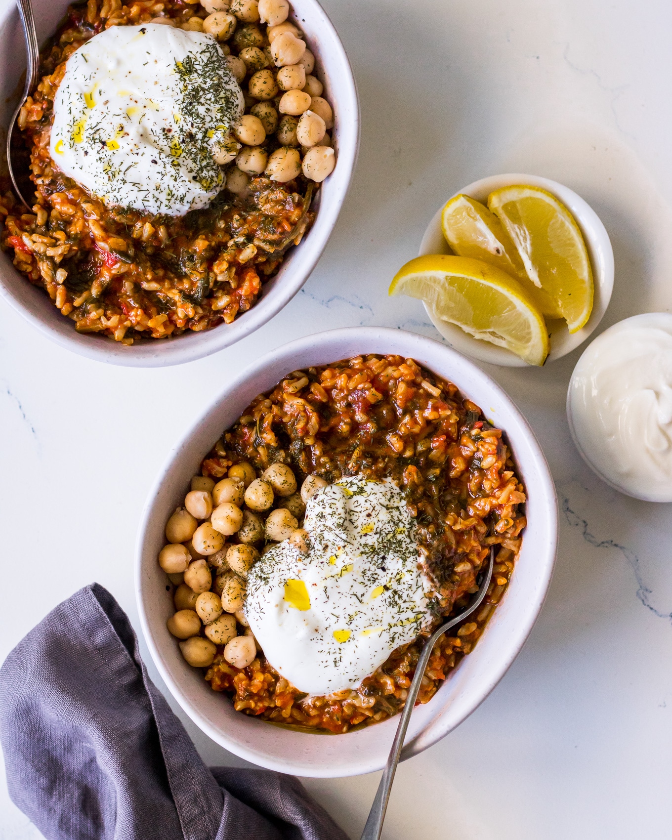 Bowls of spanakorizo (greek spinach and rice) with chickpeas and yoghurt and herbs