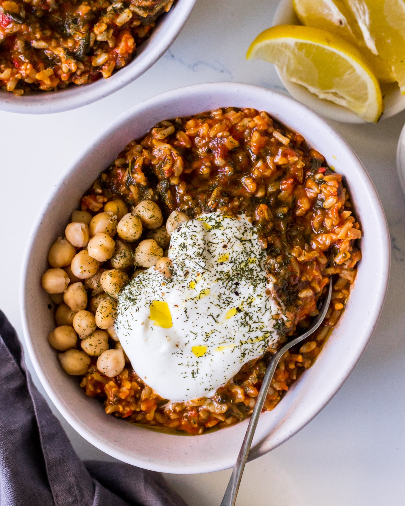 Close up bowl of spanakorizo rice dish topped with chickpeas and Greek yoghurt
