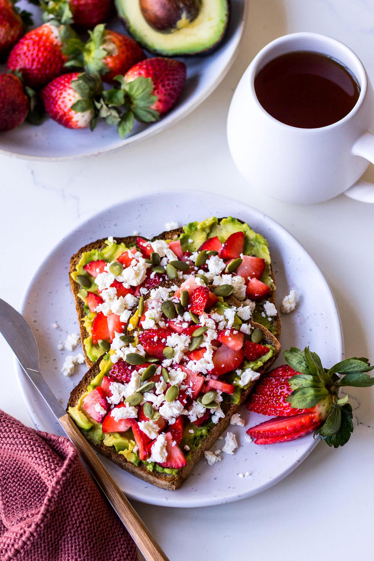 Avocado toast with diced strawberries and feta, and a cup of tea