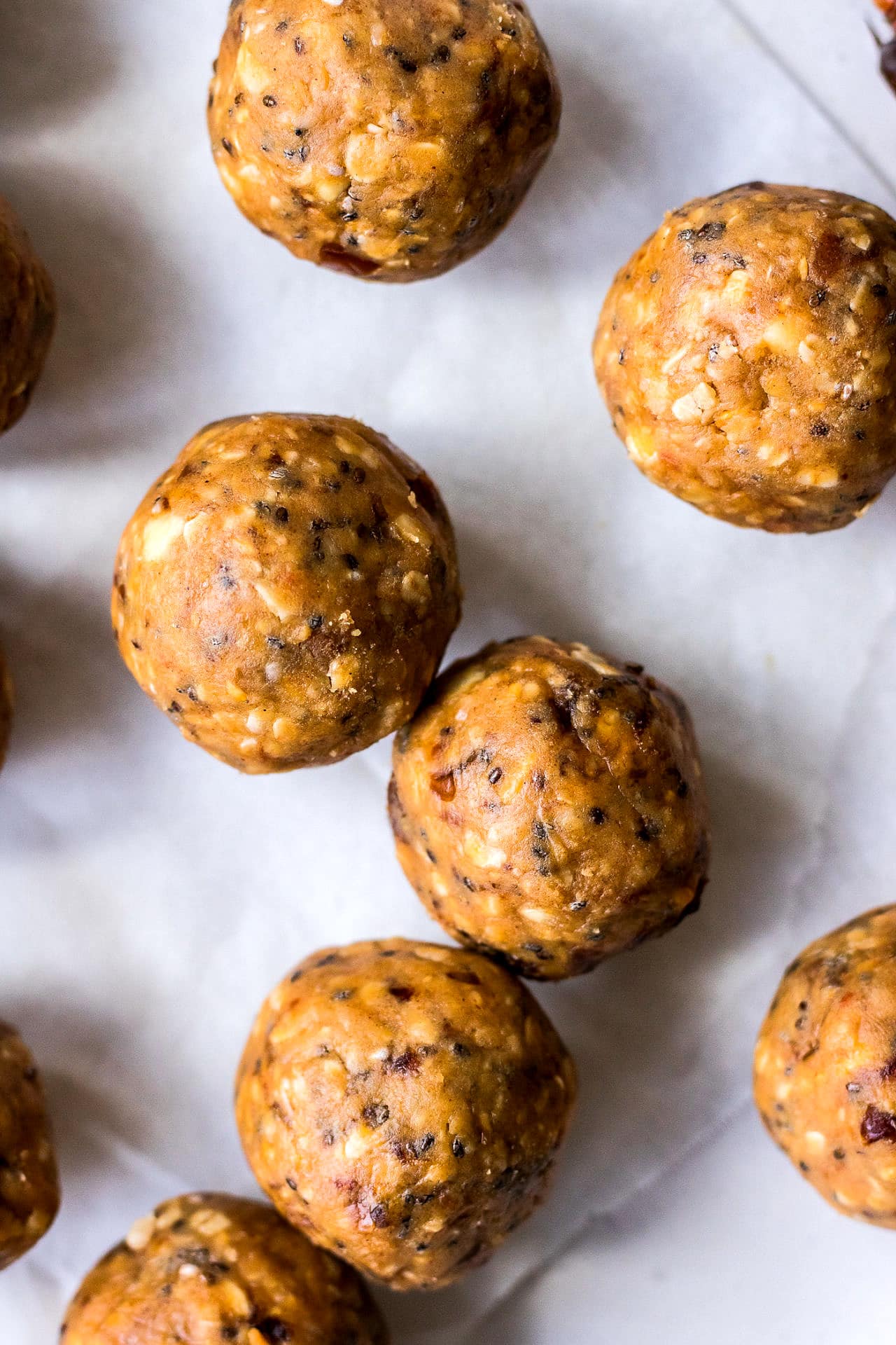 Close up shot of energy balls made with crunchy peanut butter, oats, medjool dates and chia seeds, on a white plate background