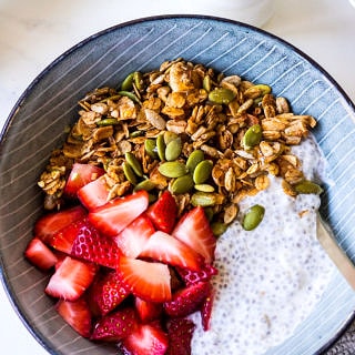 Healthy Cinnamon Granola bowl with sliced strawberries and chia pudding