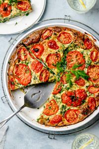 Top down view of a crustless pie made with eggs, ricotta, kale and tomatoes