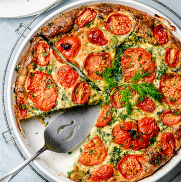 Top down view of a crustless pie made with eggs, ricotta, kale and tomatoes