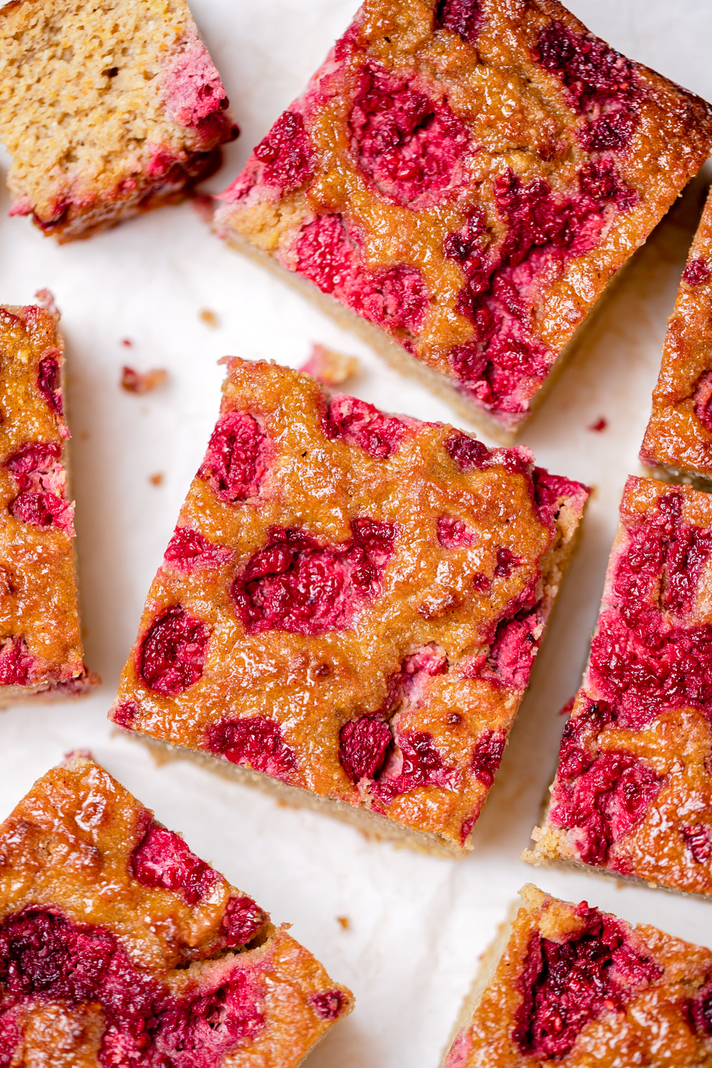 Close up squares of healthy orange almond and raspberry cake