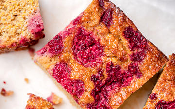Orange cake topped with raspberries cut into square slices