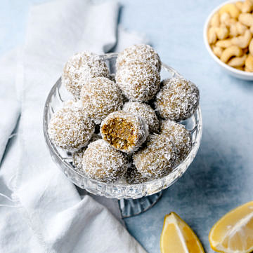 Lemon, cashew and coconut energy balls in a small glass bowl