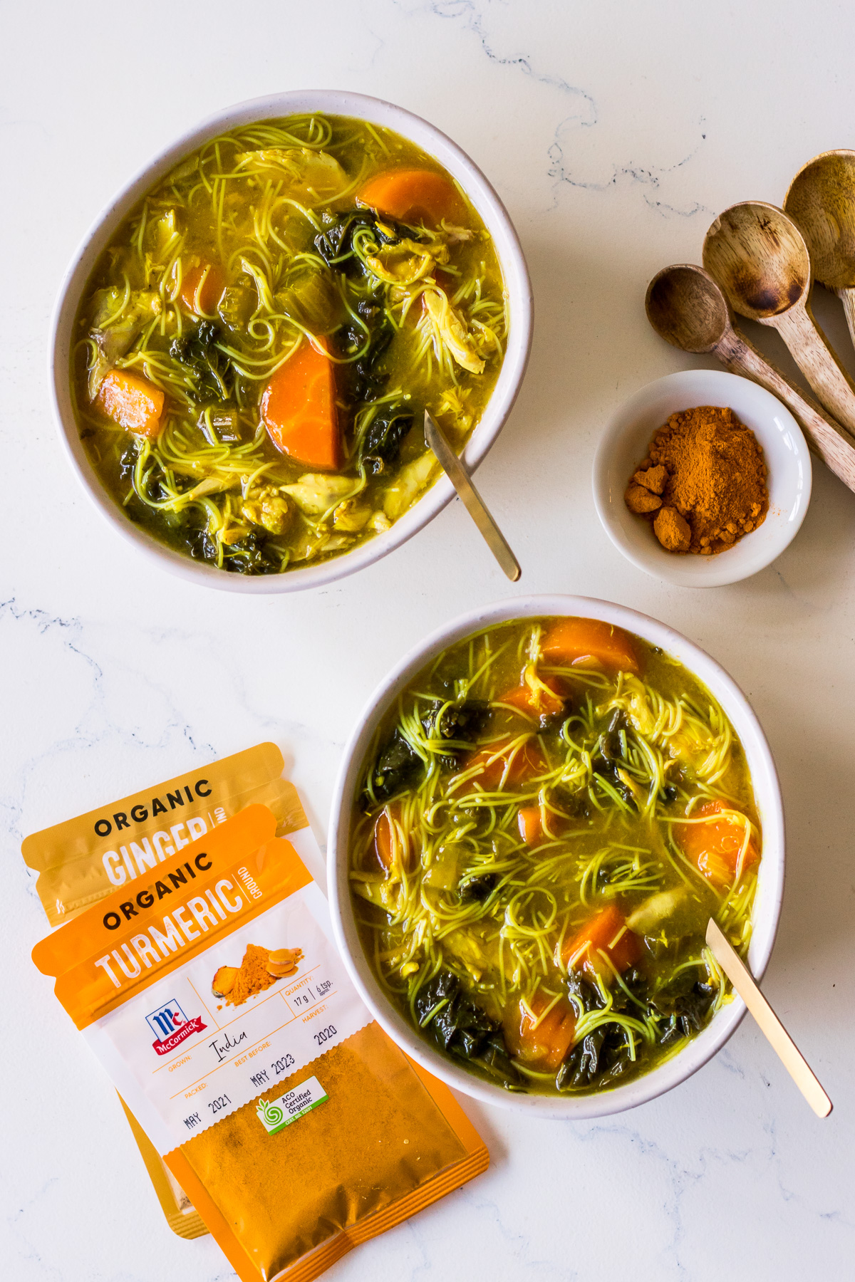 Two bowls of chicken noodle soup with McCormick Organic Turmeric and Organic Ginger spice packets