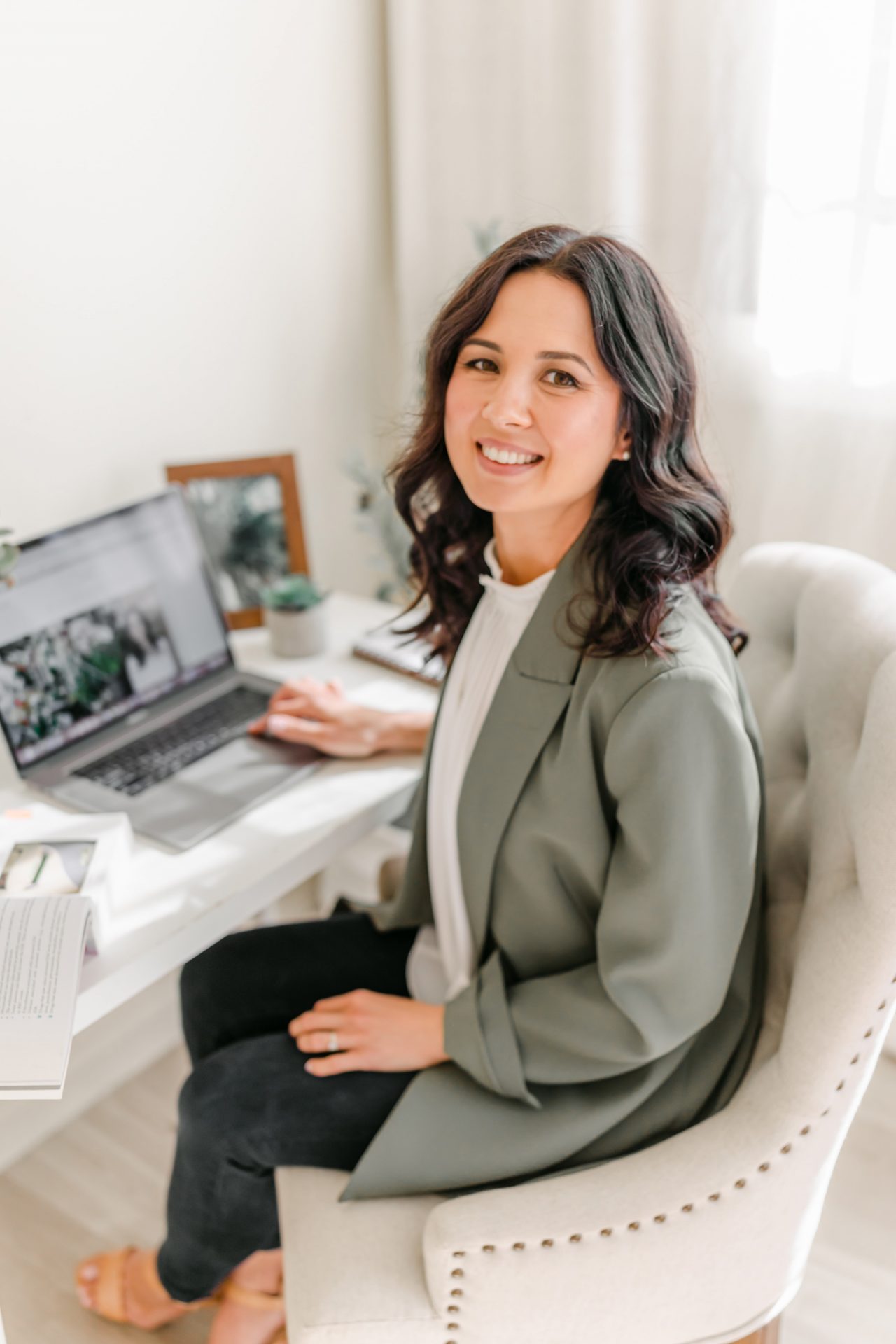 Monique Cormack sitting at a workdesk with laptop, turning to face camera