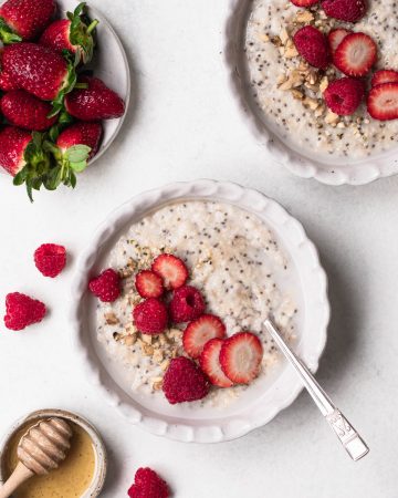 Bowl of oat and chia seed porridge topped with sliced strawberries