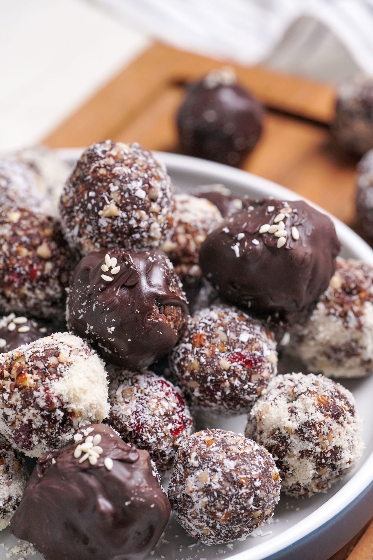 Plate of bliss ball truffles made with cranberries, dates and cacao powder, covered in melted dark chocolate