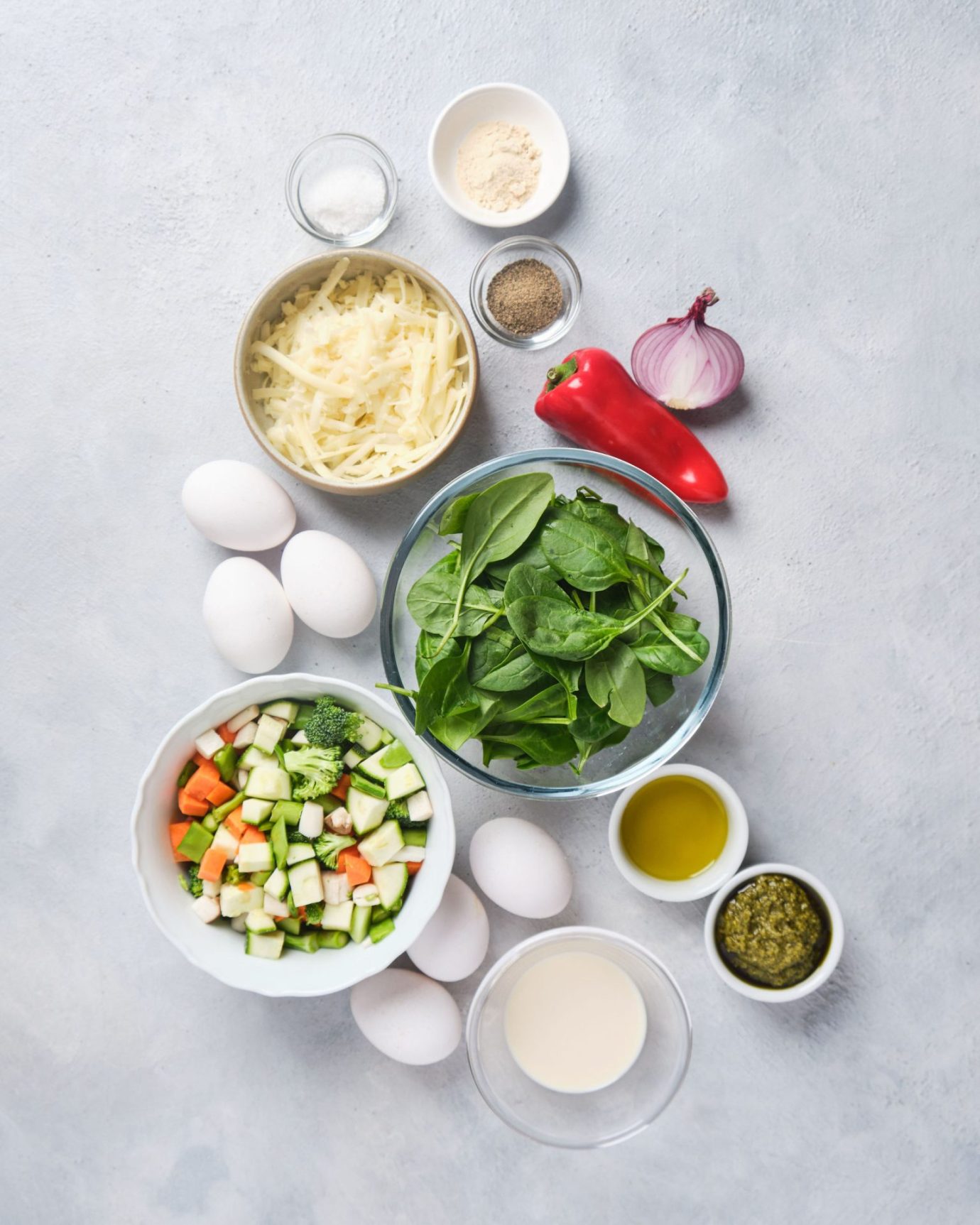 Ingredients to make pesto vegetable frittata separately arranged in small bowls