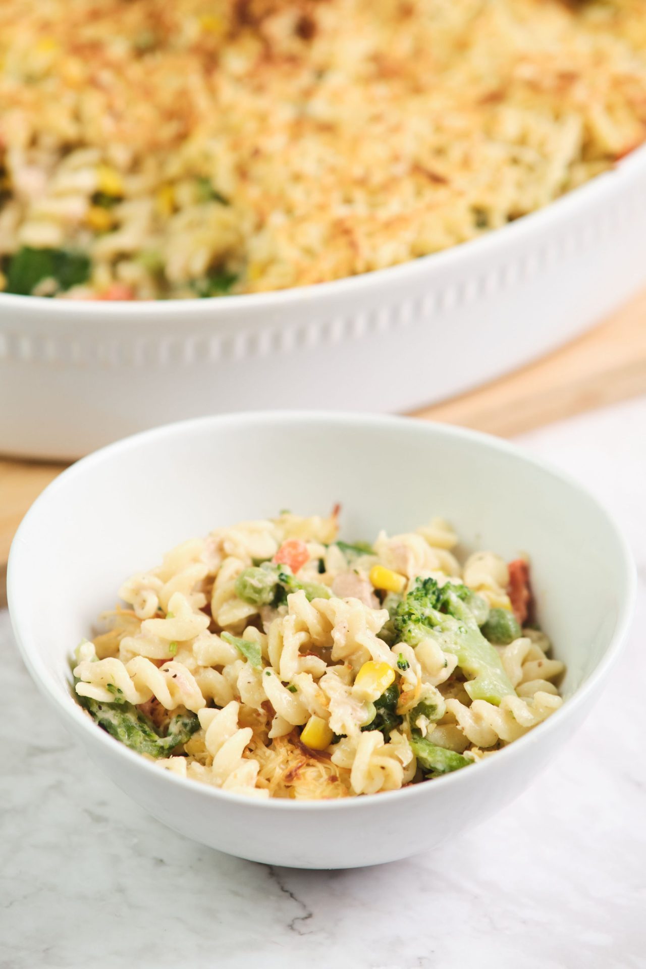 Pasta casserole in a large baking dish with tuna, cheese and vegetables