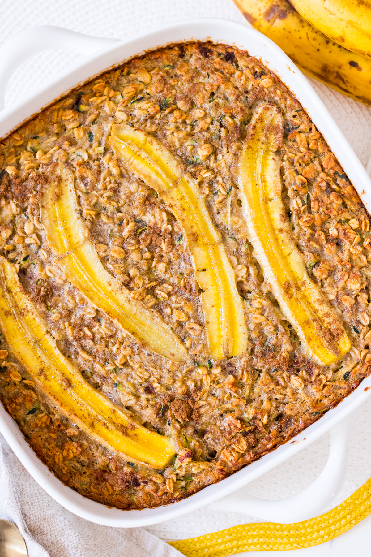 Oatmeal bake with sliced banana on top in a square baking dish