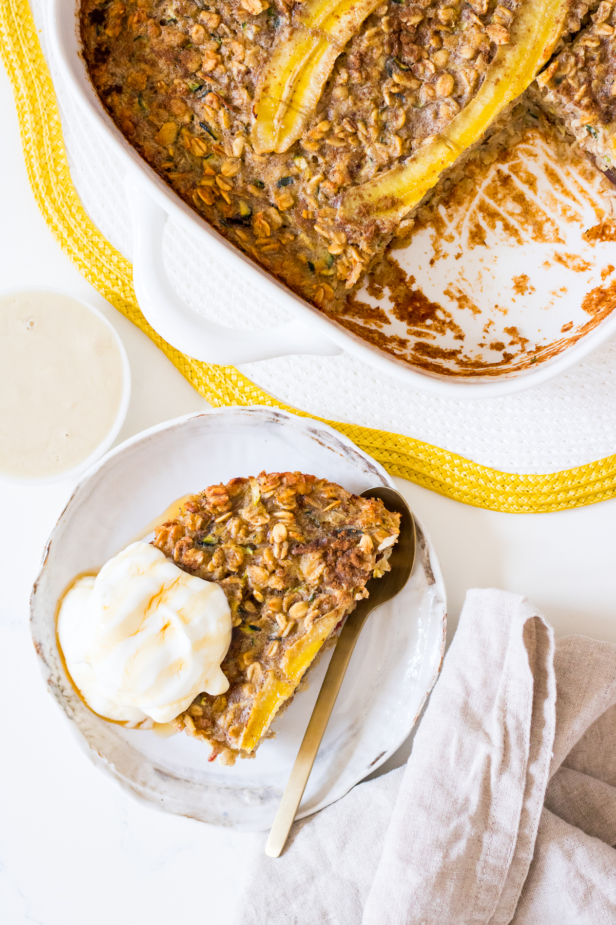 Close up of a serve of banana zucchini baked oats on a small white plate