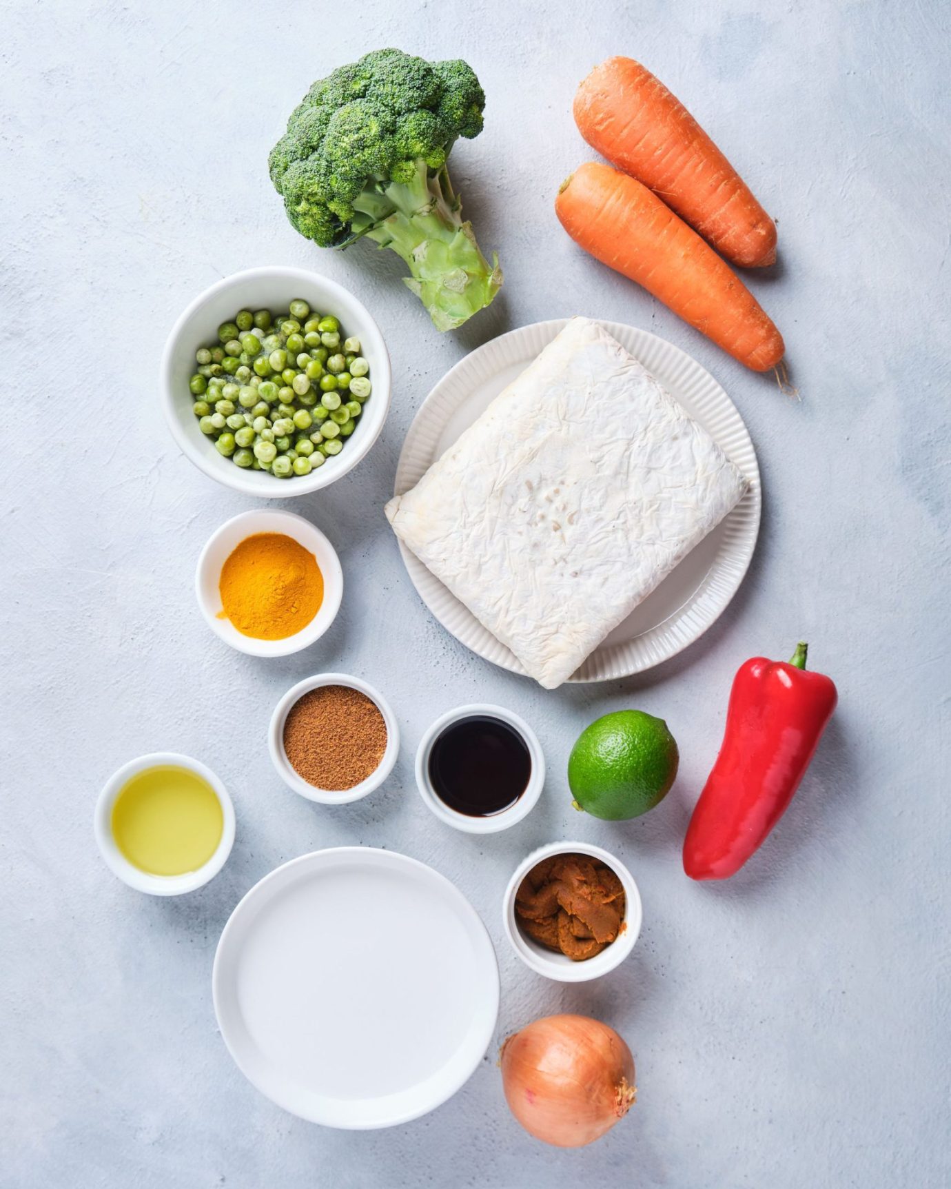 Ingredients to make yellow curry with tempeh including vegetables, curry paste and tempeh
