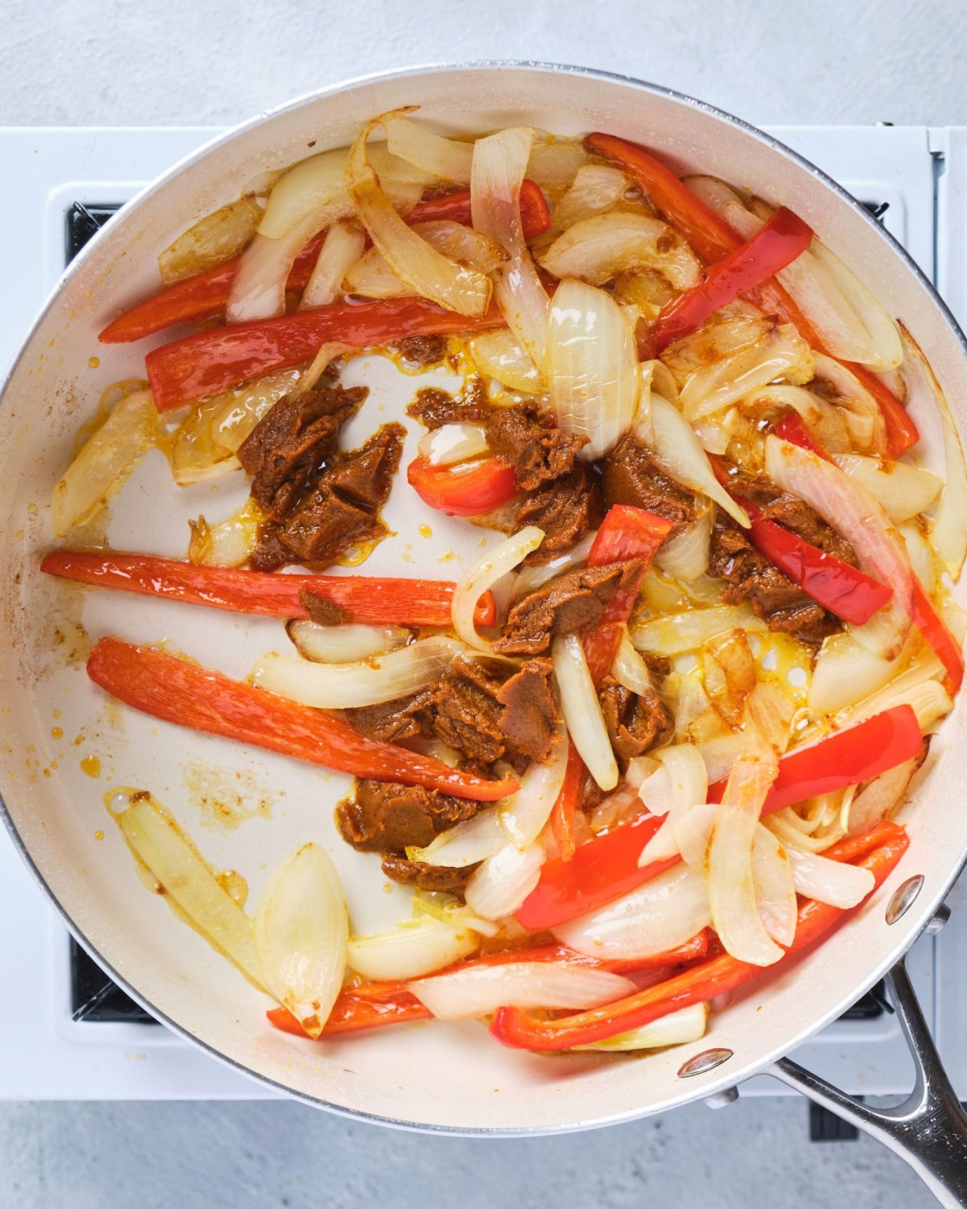 Onion, capsicum and curry paste cooking in a frypan
