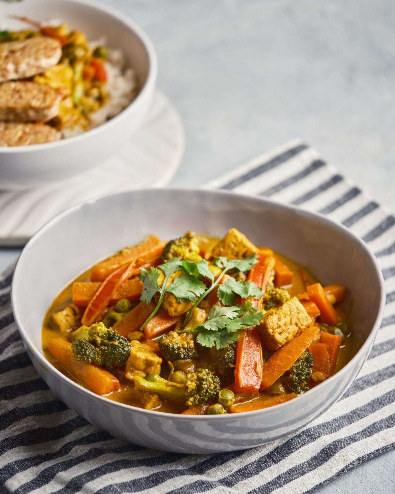 Yellow curry made with vegetables and tempeh, in a ceramic bowl