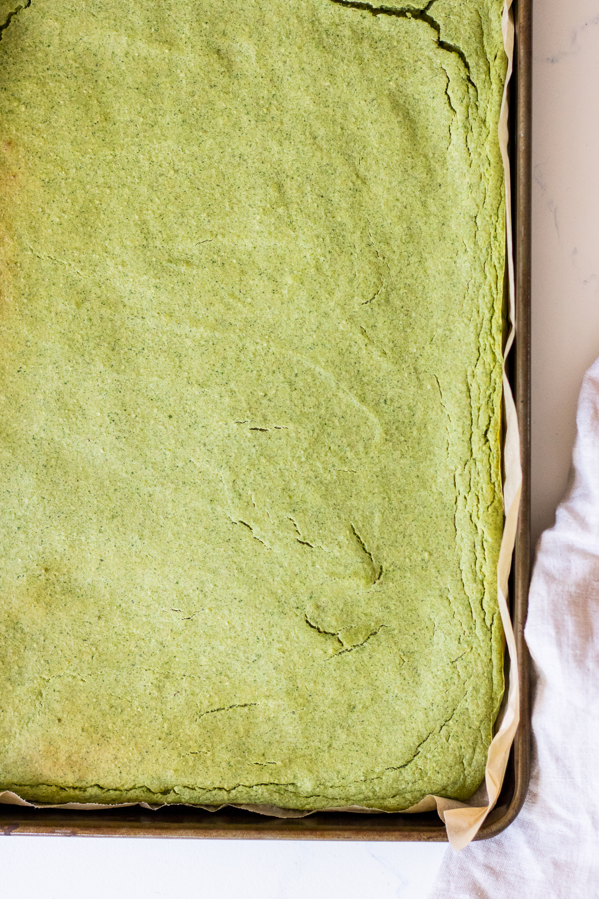 Image of a large green pancake baked into a rectangular sheet pan