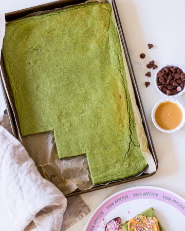 Image of healthy green pancakes baked in a baking tray, the edge cut into squares