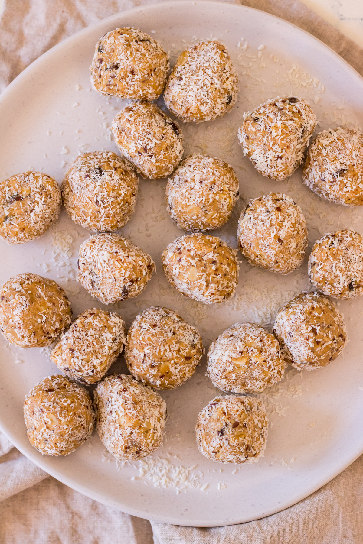 Energy balls for lactation covered in desiccated coconut on a ceramic plate
